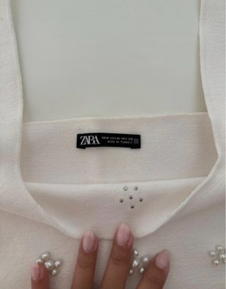 Top de punto blanco con perlas