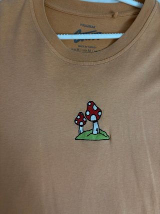 Camiseta naranja con estampado de setas