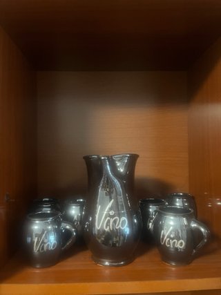 jarra de cerámica negra de vino con seis tazas