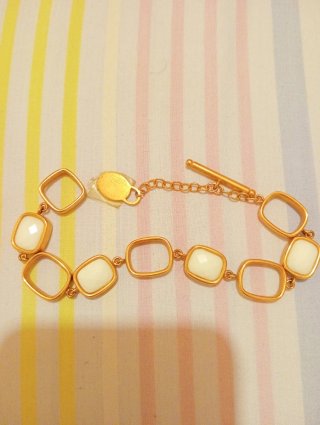 Pulsera dorada con piedras blancas