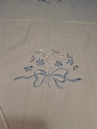 Mantelería blanca bordada flores y lazo