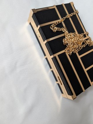 Bolso de fiesta rígido negro y dorado