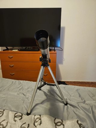 Telescopio plateado con trípode