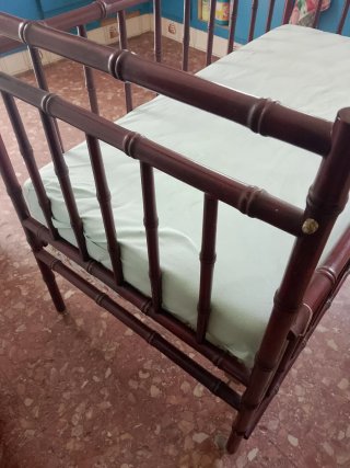 Cuna de madera con barandilla y colchón