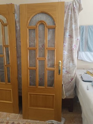 Puerta de roble con arco y manilla dorada