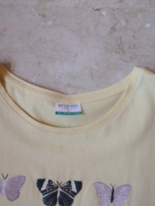 Camiseta amarilla pastel con mariposas