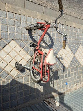 Bicicleta infantil roja con ruedines