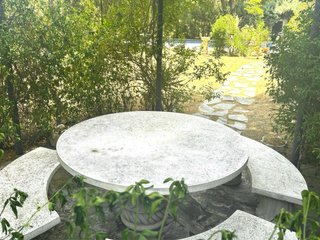 Mesa de piedra redonda con bancos