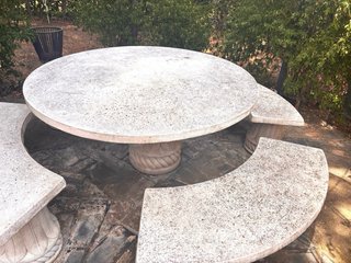 Mesa de piedra redonda con bancos
