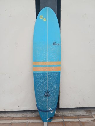 Tabla de surf azul y franja naranjas con diseño.