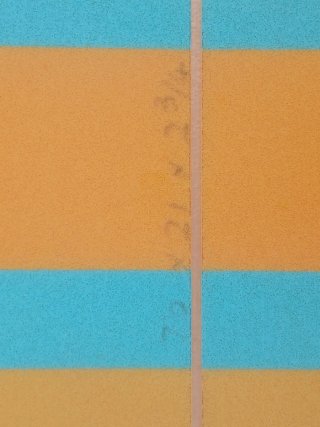 Tabla de surf azul y franja naranjas con diseño.