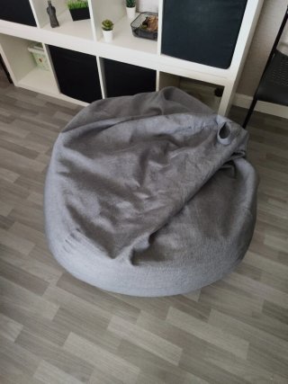 Puf de tela gris Costó en tienda 60 euros