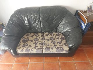 Sofá de piel negro con cojines estampados
