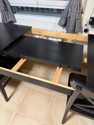 Mesa de comedor negra de madera.
