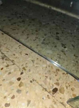 Mesa de cristal templado con base de piedra