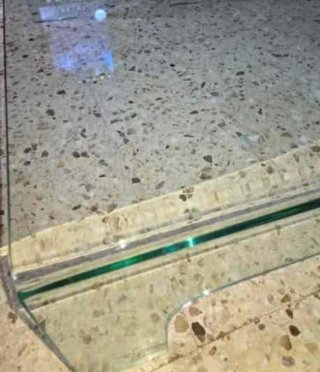 Mesa de cristal templado con base de piedra