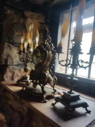 Orologio antico e candelabri in metallo. Tavolo e sedie