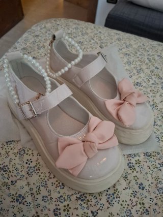 Zapatos charol blanco lazo rosa.