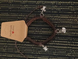 Pulsera de cuero con dijes de diferentes diseños.