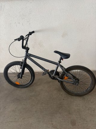 Bicicleta BMX gris, cable trasero un poco suelto