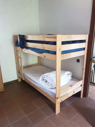 Literas de madera con colchón y edredón