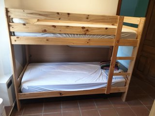 Literas de madera con colchón y edredón