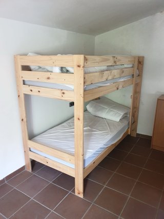 Literas de madera con colchón y edredón
