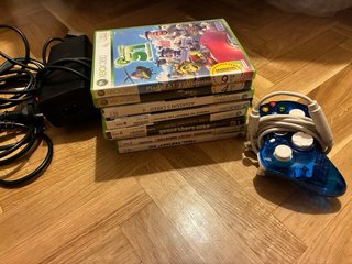 Xbox 360 con mando azul y juegos