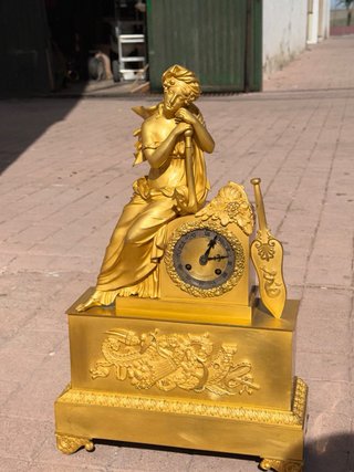 Reloj de sobremesa dorado con figura