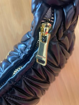 Bolso Miu Miu negro con detalles dorados