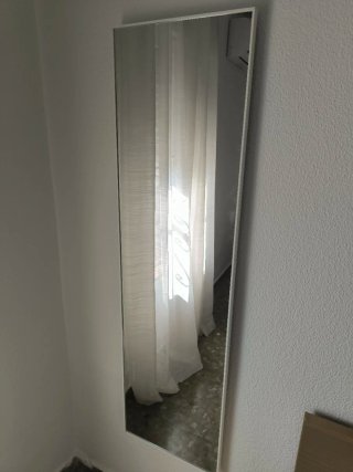 Espejo de pared con marco blanco.