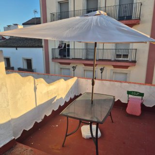 Mesa de cristal y sombrilla beige