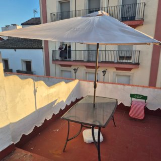 Mesa de cristal y sombrilla beige