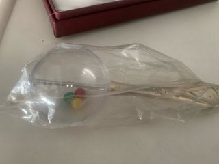 Sonajero bebé de plata con cascabeles de colores