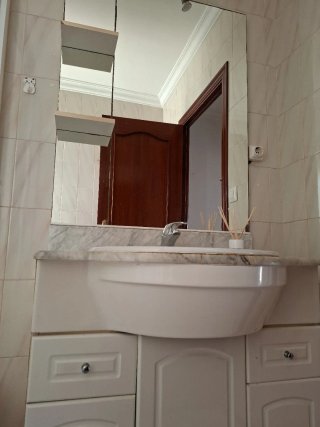 Mueble de lavabo, encimera de mármol y espejo.