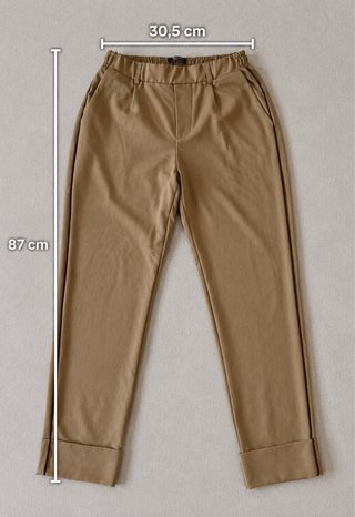 Pantalón beige elegante con raya lateral negra.