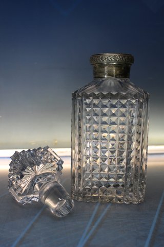 Antica bottiglia per liquori, decanter in vetro intagliato e argento scolpito.