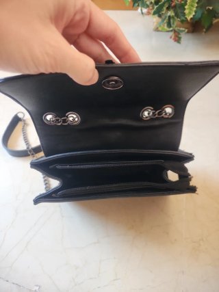 Bolso negro con cadena y pluma