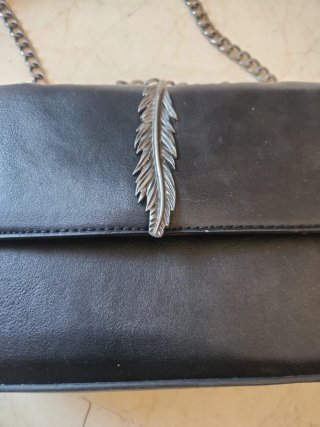 Bolso negro con cadena y pluma
