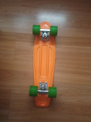 Monopatín naranja con ruedas verdes