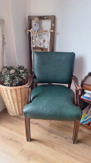 Silla de piel verde con estructura de madera