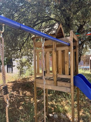 Parque infantil exterior con columpios y tobogán