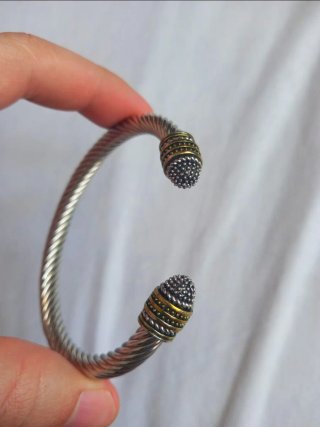 Pulsera de acero trenzada con detalles dorados