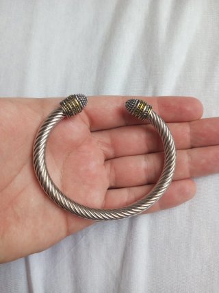 Pulsera de acero trenzada con detalles dorados