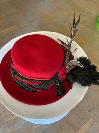 Sombrero rojo y negro con plumas