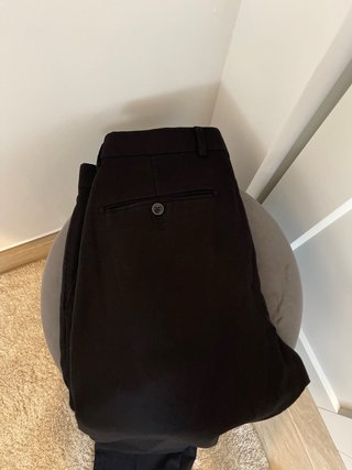 Pantalón de vestir negro con botón rojo