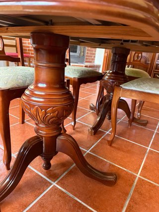 Mesa ovalada de madera con detalles dorados