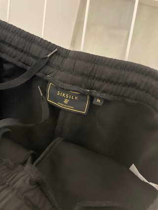 Pantalón chándal SikSilk negro con rayas arcoíris
