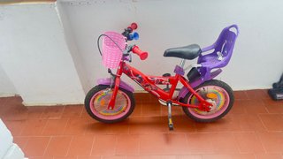 Bicicleta infantil roja con cesta y sillín