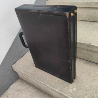 Maletín de piel negro con detalles dorados